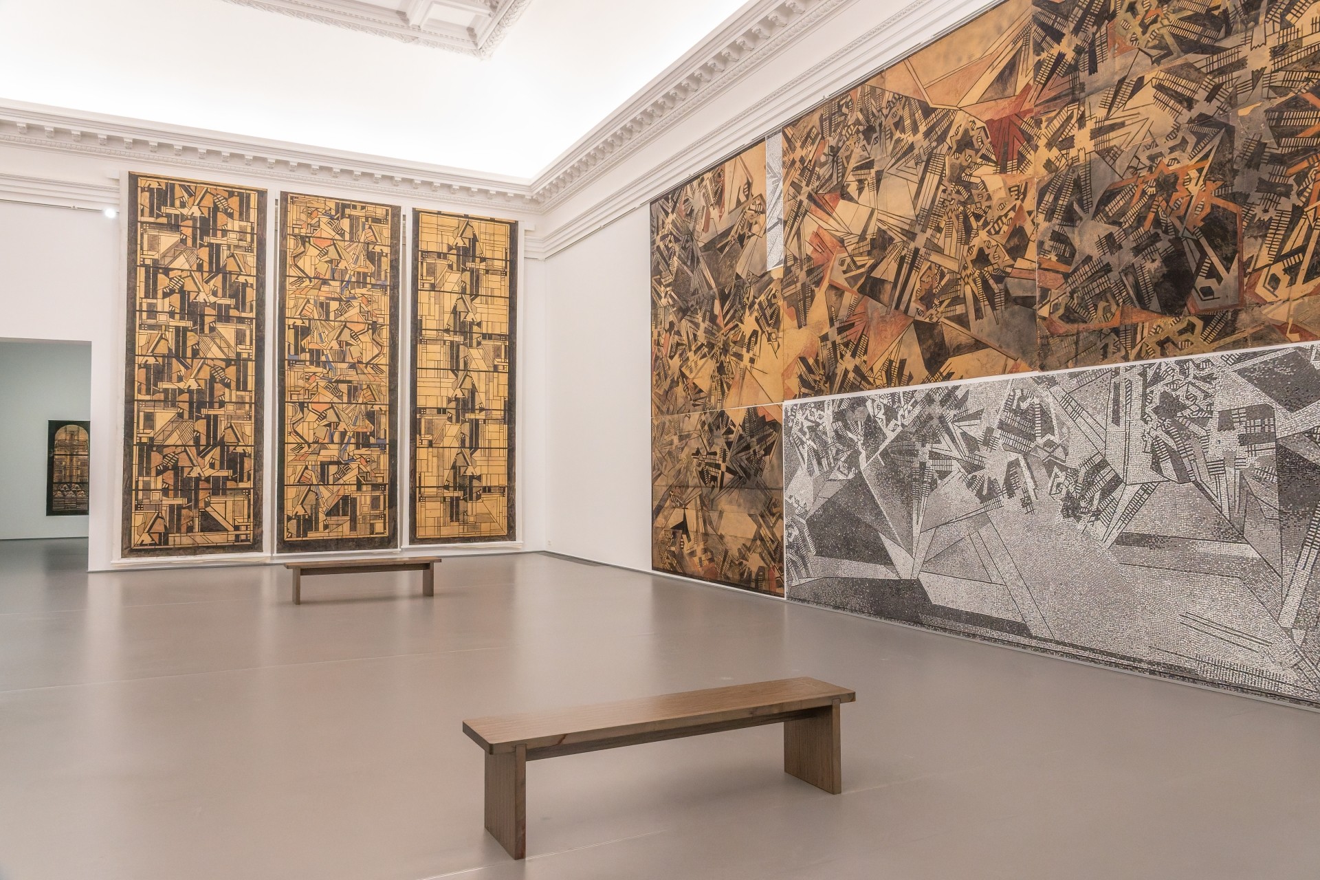 Heller Ausstellungssaal im Kaiser-Wilhelm-Museum mit großformatigen, abstrakten Wandarbeiten in Braun-, Beige-, Schwarz- und Grautönen. Zwei schlichte Holzbänke stehen im Raum.