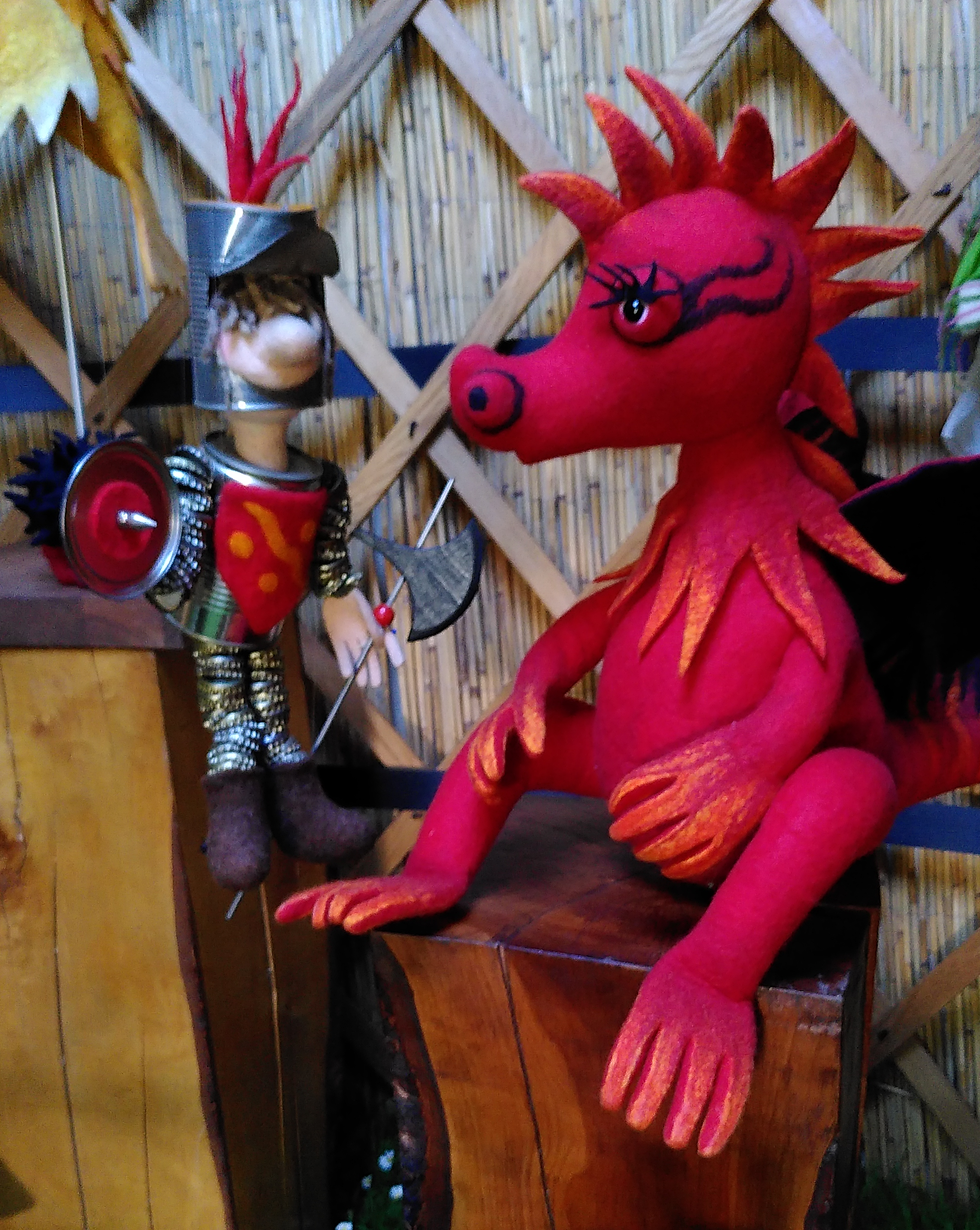 Ein gefilzter Drache kommuniziert mit einer Ritterfigur
