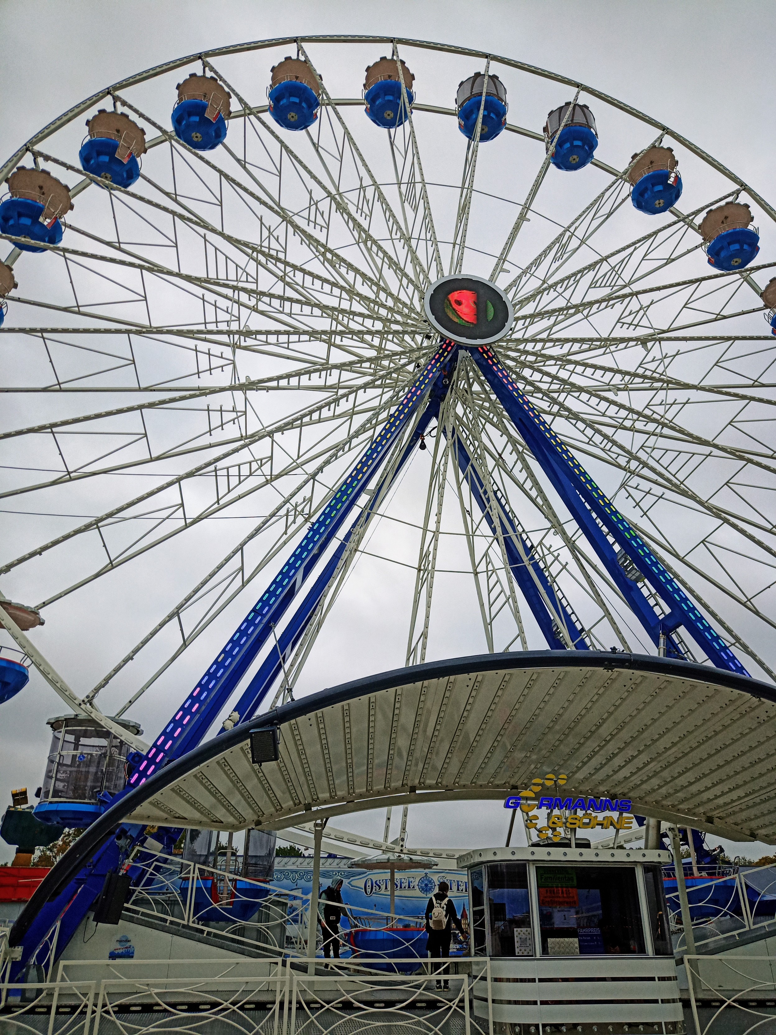 Ein Riesenrad vor grauem Himmel.